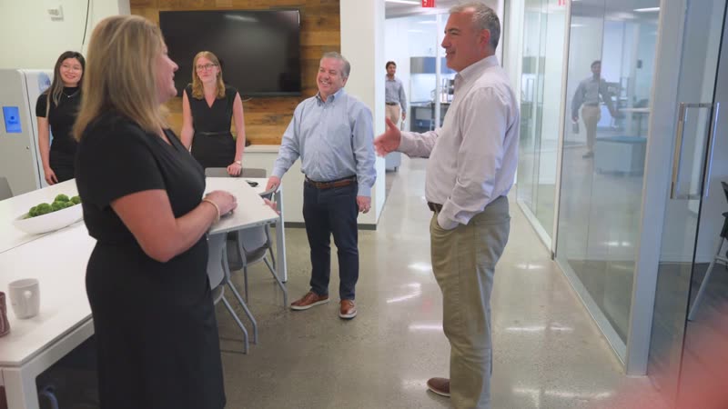 Colleagues talking in a bright open office